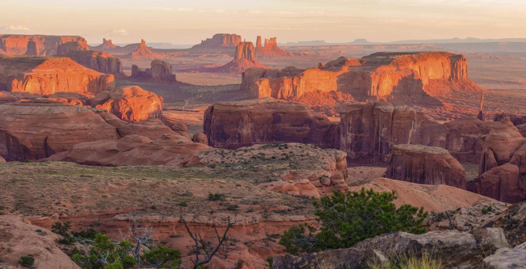 A scenic desert landscape with red rock formations glowing under the soft sunlight in apache junction az