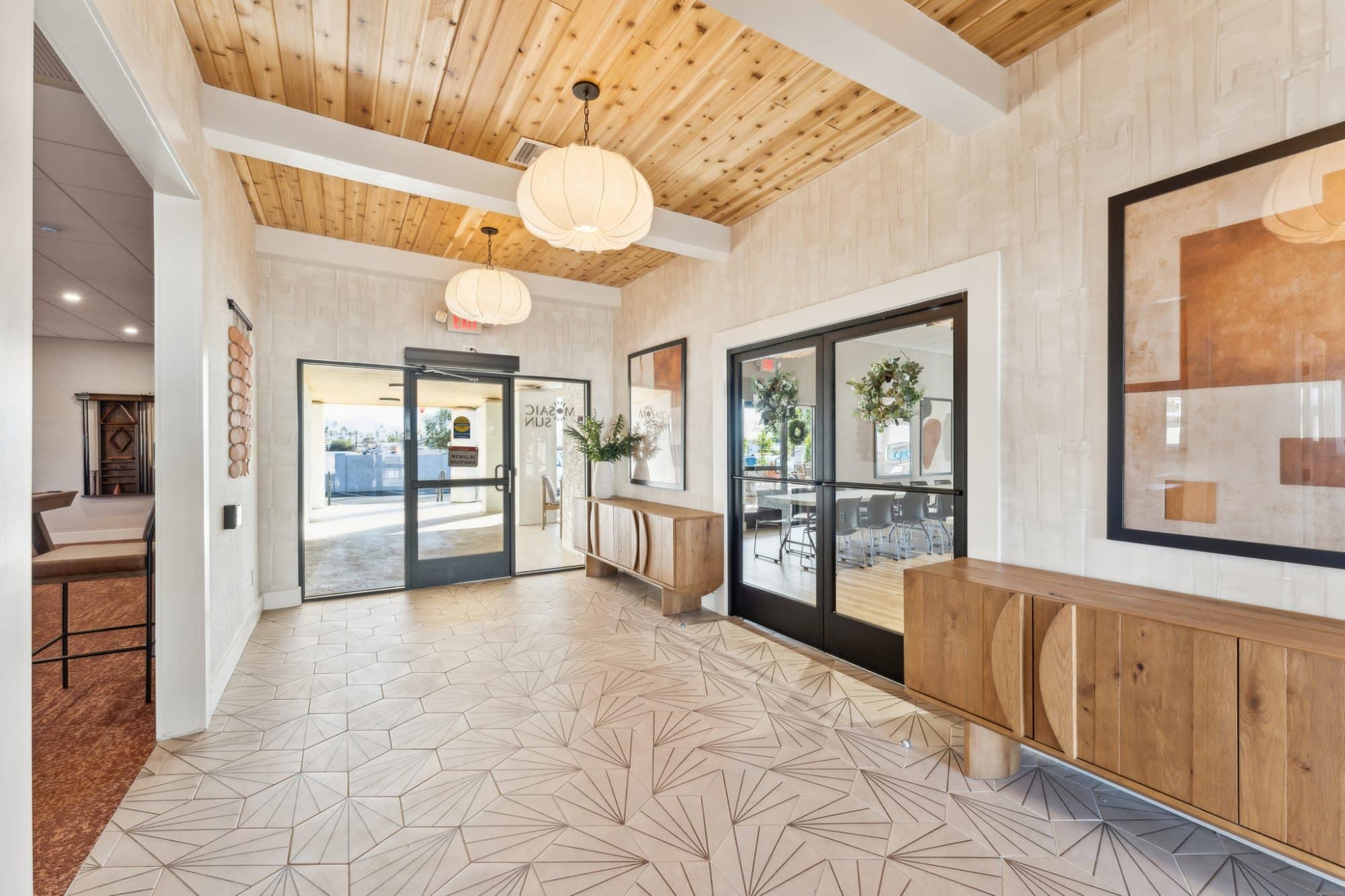 Bright lobby with wood accents, geometric tile flooring, modern light fixtures, and glass doors leading outside in apache junction az